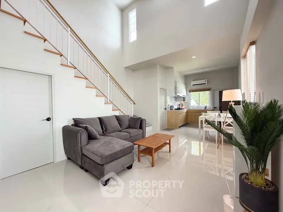 Spacious modern living room with high ceiling and open kitchen layout