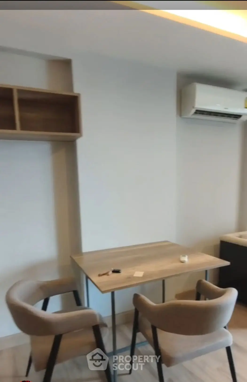 Modern study area with sleek table and chairs, featuring air conditioning and minimalist design.