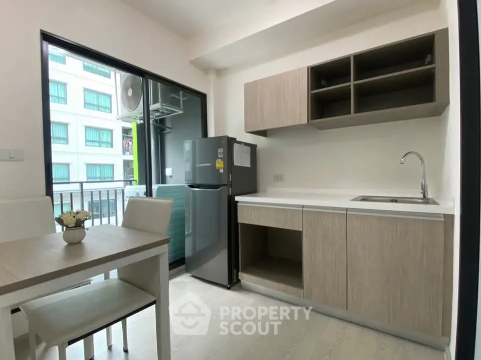 Modern kitchen with sleek cabinetry and dining area in a bright apartment