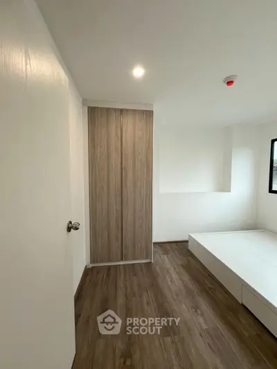 Modern minimalist bedroom with wooden flooring and built-in wardrobe