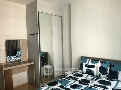Modern bedroom with stylish bedding and mirrored wardrobe in a cozy apartment.