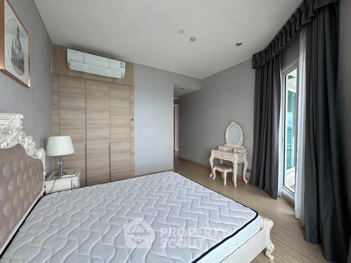 Spacious bedroom with elegant decor and balcony access in modern apartment.