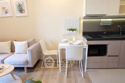 Modern open-plan living room and kitchen with stylish decor and compact dining area.