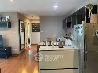 Modern open-layout kitchen and living area with stylish decor and wooden flooring.