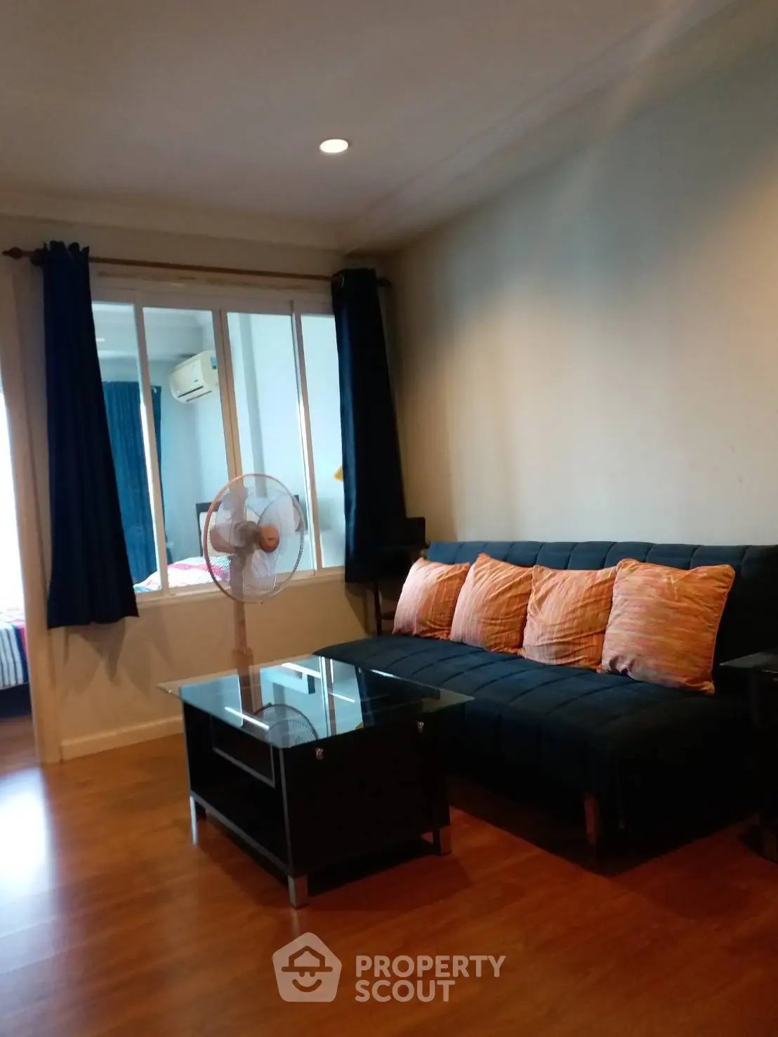 Cozy living room with modern sofa and glass coffee table, perfect for relaxation.