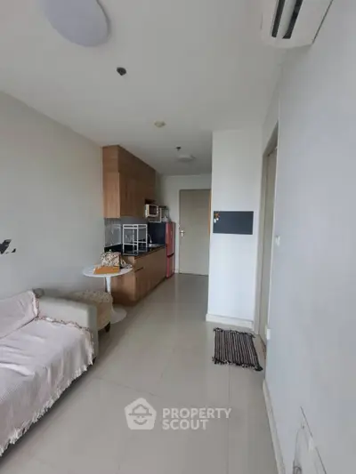 Modern studio apartment with compact kitchen and cozy living area, perfect for urban living.
