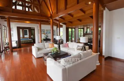 Spacious living room with high wooden ceilings and elegant furnishings in a luxury home.