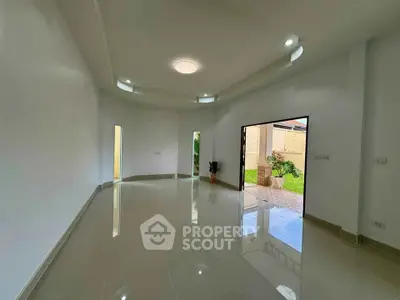 Spacious modern living room with glossy tiled floors and garden view.