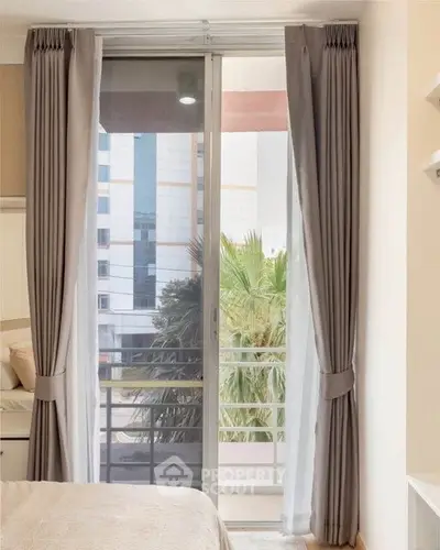 Cozy bedroom with balcony view and elegant curtains in modern apartment