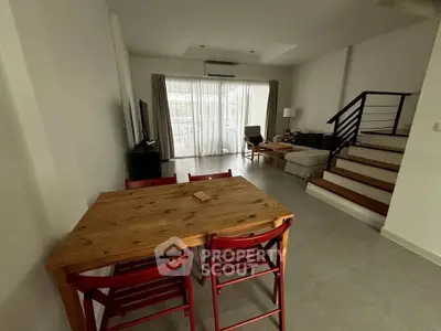 Spacious living room with modern staircase and natural light, perfect for family gatherings.