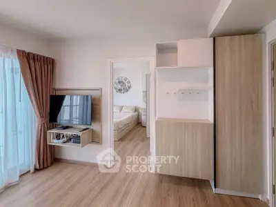 Modern apartment interior with wooden flooring, wall-mounted TV, and cozy bedroom view.
