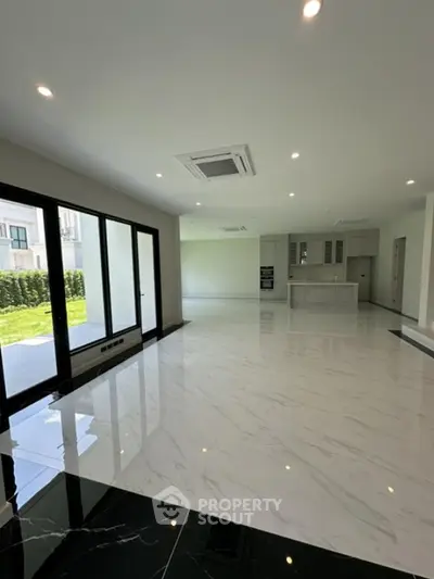 Spacious modern living room with open kitchen and garden view