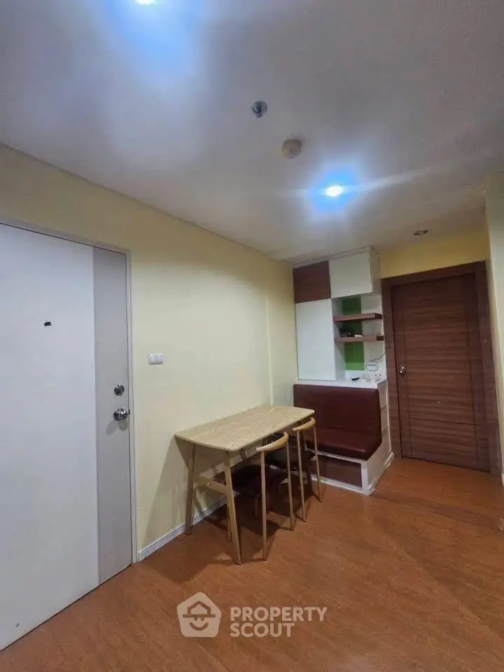 Cozy dining area with wooden table and chairs in a compact apartment setting.