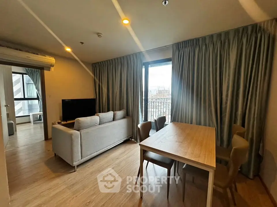 Spacious living room with modern furniture and natural light in a stylish apartment.