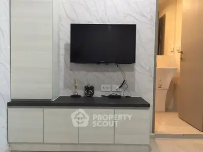 Modern living room with wall-mounted TV and sleek cabinetry
