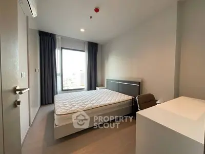 Modern bedroom with large window and minimalist furniture in high-rise apartment.