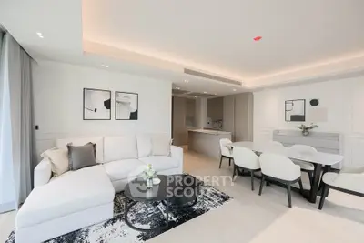 Luxurious modern living room with open kitchen and elegant dining area, featuring stylish decor and ample natural light.
