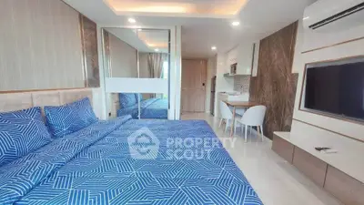 Modern studio apartment with stylish decor and open layout, featuring a cozy bed and sleek kitchenette.
