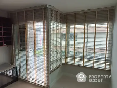 Modern corner unit with large windows and stylish blinds in a bright room.