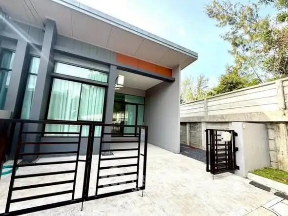 Modern single-story home with sleek exterior and gated entrance.