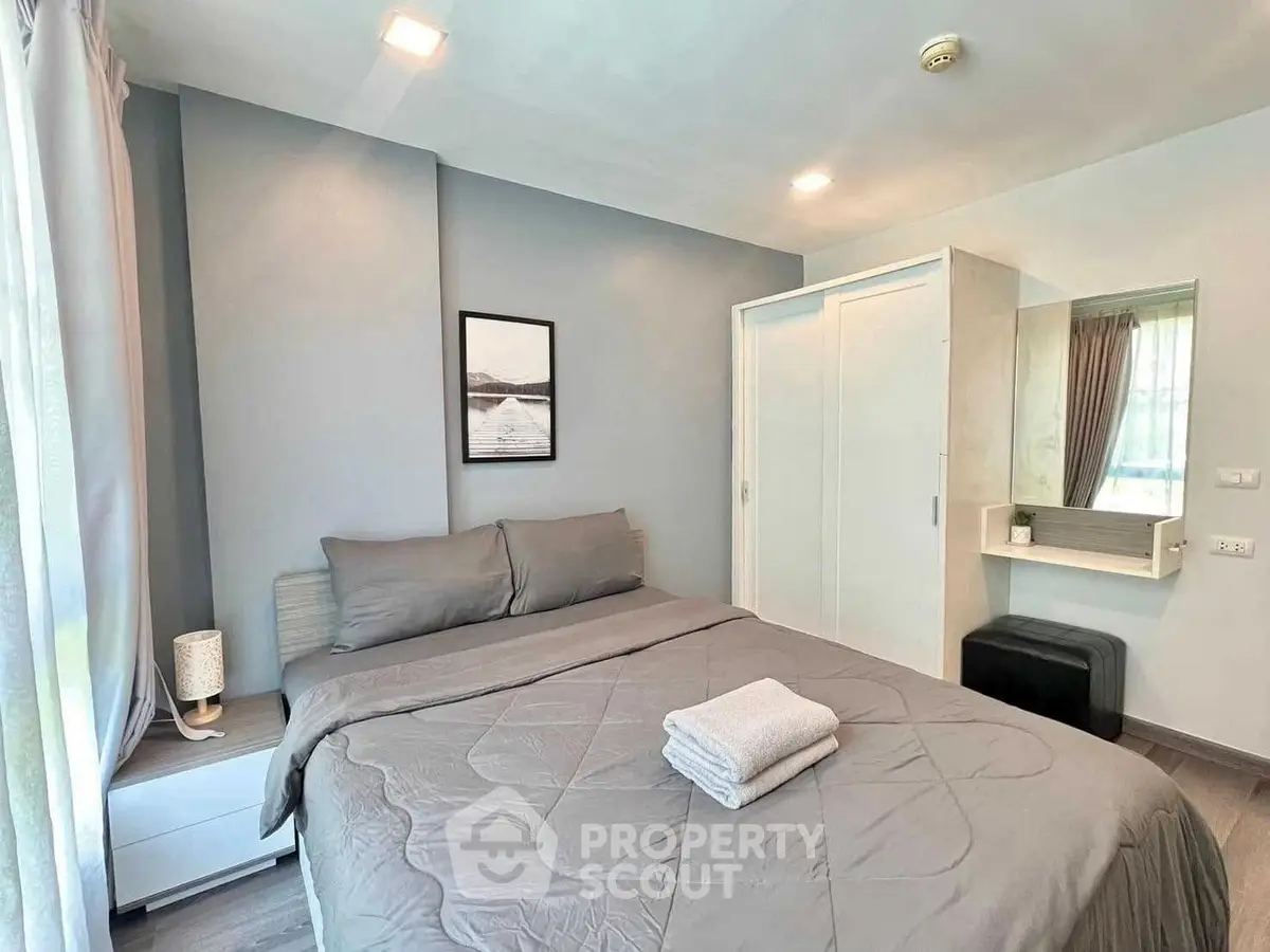 Modern bedroom with cozy gray bedding and ample natural light
