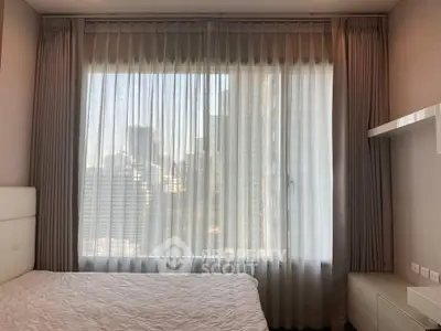 Modern bedroom with large window and city view, featuring elegant curtains and minimalist decor.