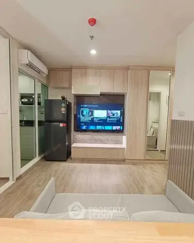 Modern living room with built-in TV unit and sleek kitchen appliances