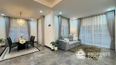 Elegant spacious living room with polished marble floors, luxurious chandelier, and large windows draped in sheer curtains, perfect for upscale living.