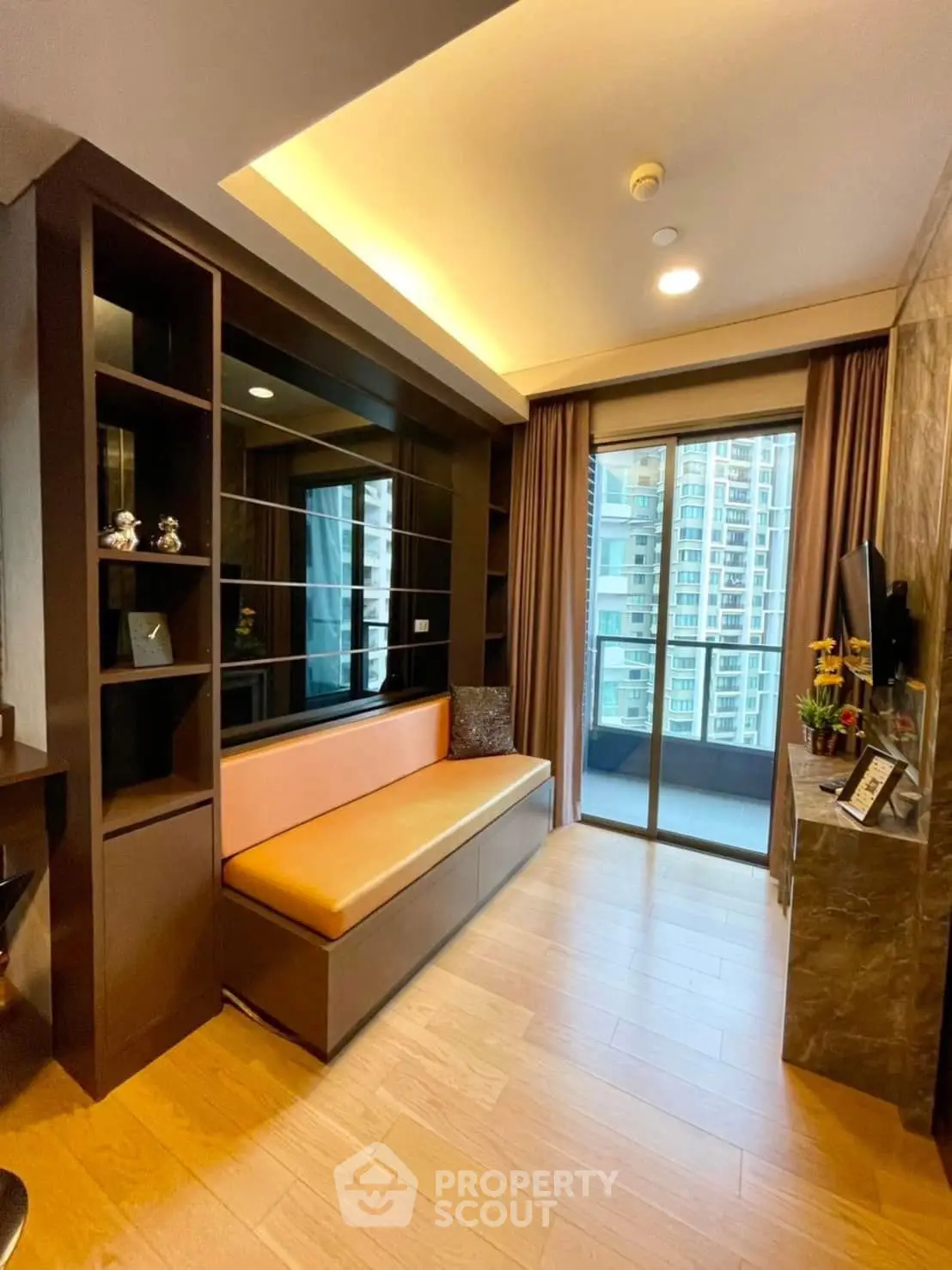 Modern living room with built-in seating and balcony view in urban apartment