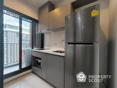 Modern kitchen with sleek cabinets and stainless steel appliances in high-rise apartment