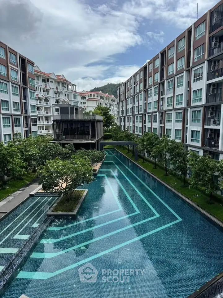 Luxurious condominium with stunning pool and lush greenery, offering a serene and modern living experience.