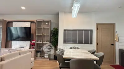 Modern living room with dining area, featuring sleek furniture and stylish decor.