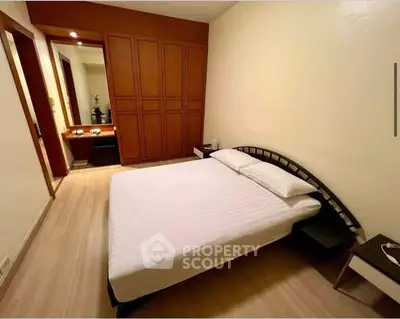 Spacious bedroom with modern design and ample storage in a cozy apartment.