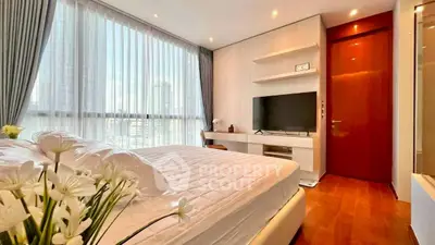Luxurious bedroom with modern decor and large windows offering city views.