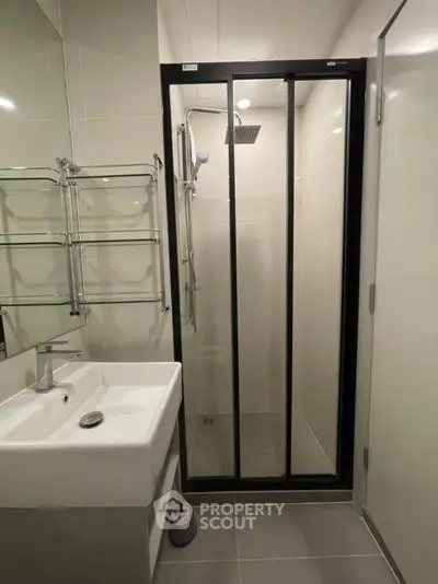 Modern bathroom with sleek shower enclosure and stylish sink in a contemporary apartment.