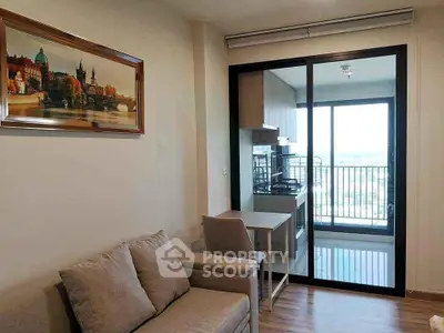 Modern living room with balcony view and stylish kitchen in open layout apartment.
