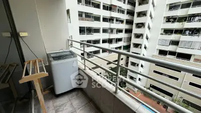 Urban apartment balcony with washing machine and city view, ideal for modern living.