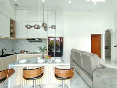 Modern open-layout kitchen and living room with stylish decor and marble finishes.