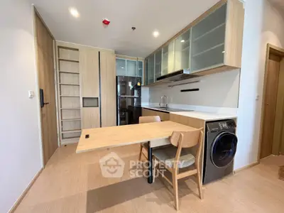 Modern kitchen with integrated appliances and wooden cabinetry in a stylish apartment.