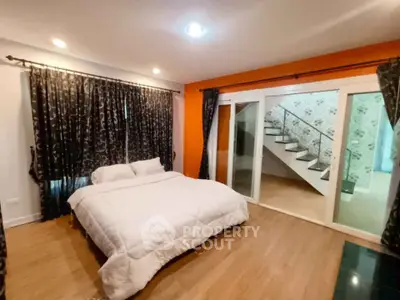 Spacious bedroom with modern decor and sliding glass doors leading to a stylish staircase.
