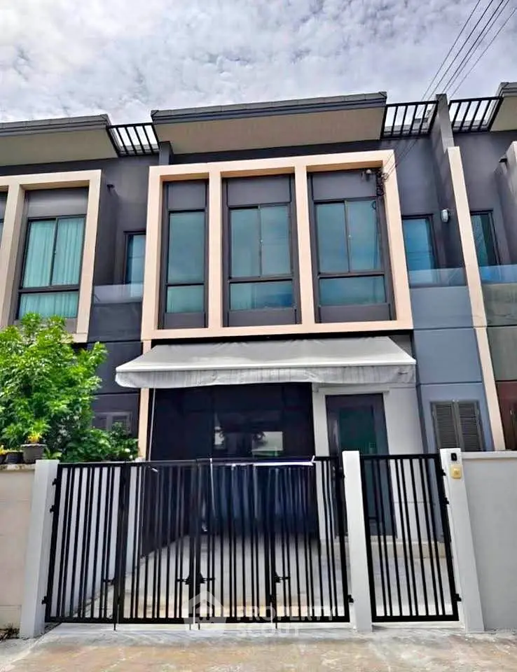 Modern townhouse exterior with sleek design and gated entrance, perfect for urban living.