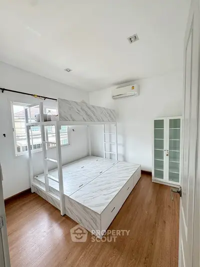Modern bedroom with stylish bunk bed and wooden flooring in bright apartment