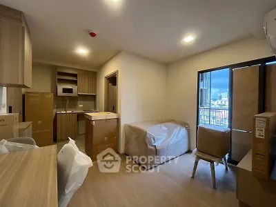 Modern apartment interior with open kitchen and balcony view, featuring new furniture and appliances.