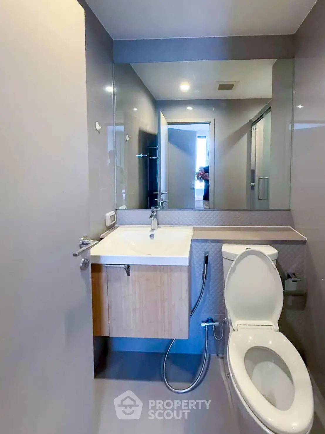 Modern bathroom with sleek fixtures and large mirror in a contemporary apartment.