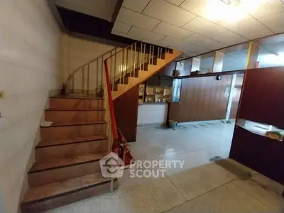 Spacious interior with unique staircase and open layout, ideal for renovation.