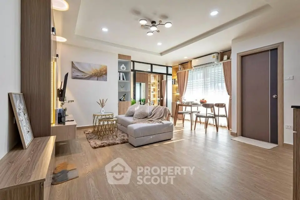 Modern living room with stylish decor and open layout, featuring cozy seating and elegant lighting.