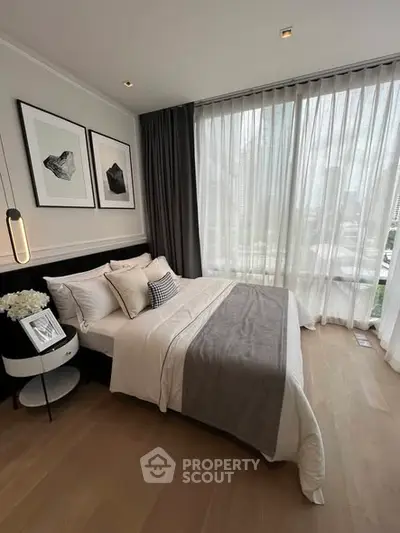 Luxurious bedroom with city view, elegant decor and floor-to-ceiling windows.