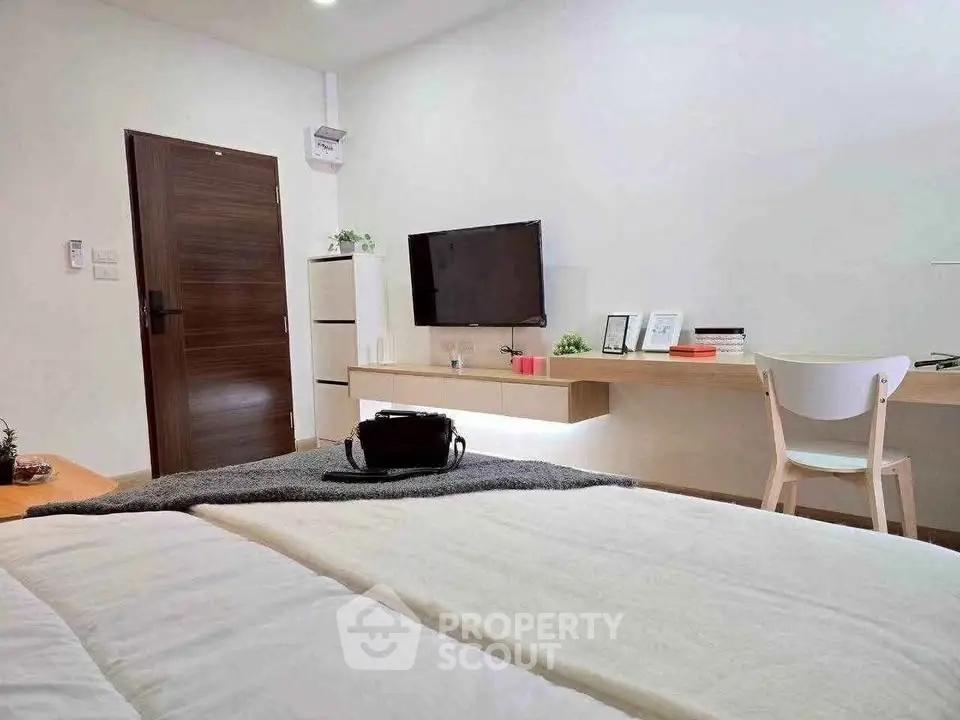 Modern bedroom with sleek TV setup and cozy decor, perfect for relaxation and comfort.