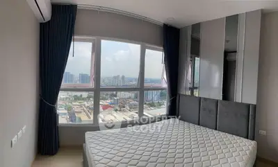 Modern bedroom with large windows offering stunning city views, featuring a comfortable bed and elegant curtains.