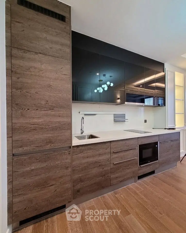 Modern kitchen with sleek wooden cabinetry and built-in appliances